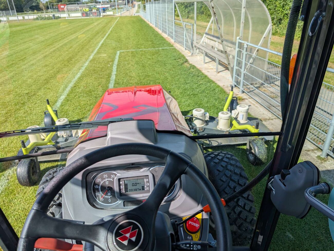 Vanuit de trekkercabine over een sportveld