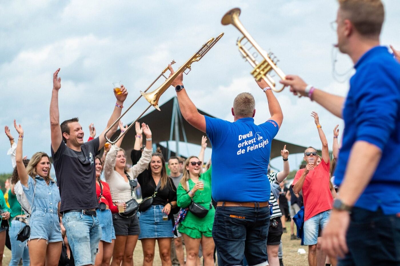 Het orkest speelt tussen het publiek op een festival