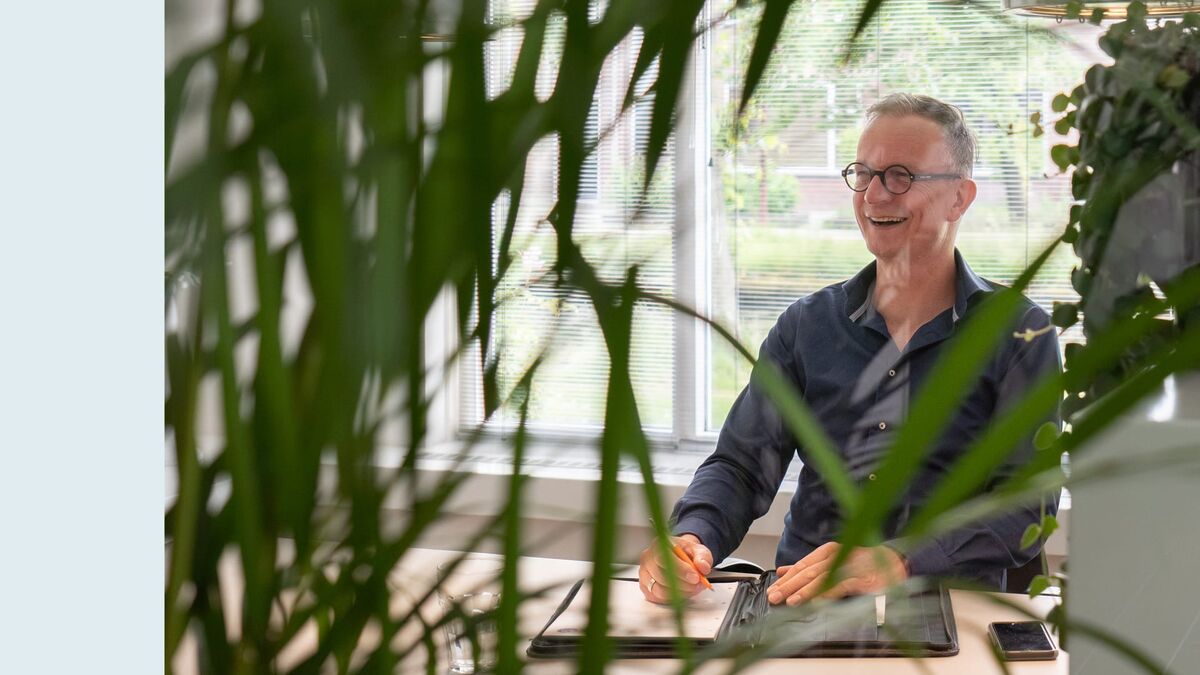 Jouke Wijnja aan zijn bureau tussen de planten