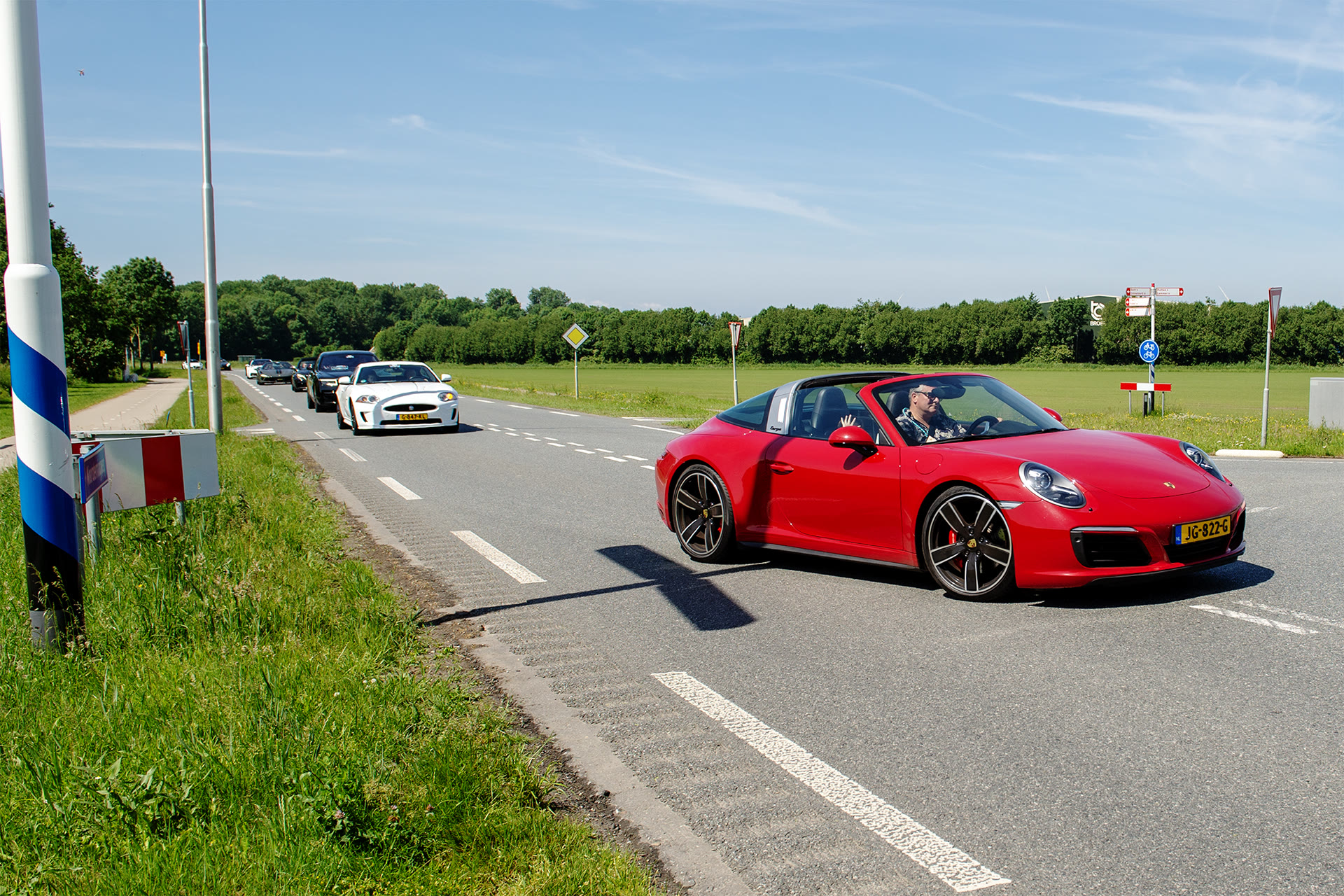 Een rode sportauto rijdt voorop in de stoet van The Ride for You 2026