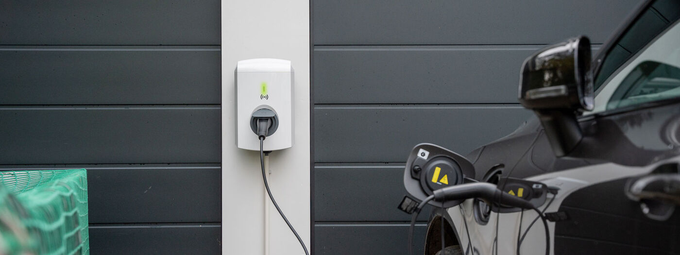 Een laadpaal naast een elektrische auto